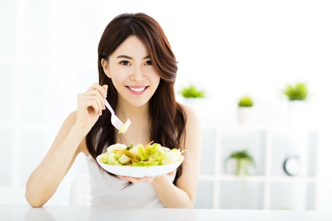 Emakume japoniarrak entsalada bat jaten du